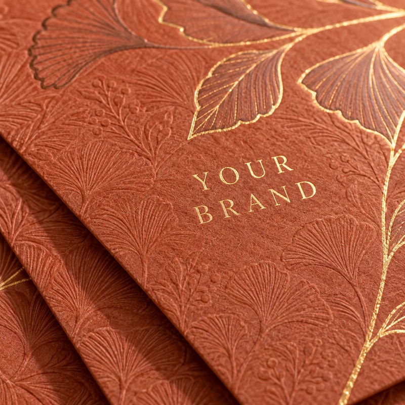 Botanical embossed terracotta paper with gold lettering