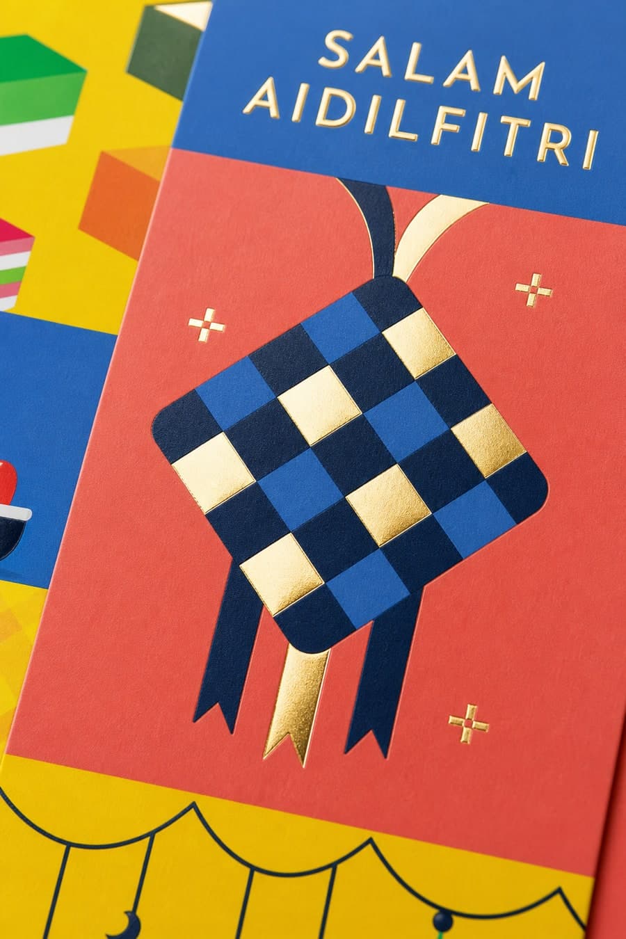Close-up of a Raya money packet showing gold foil ketupat detail stamped into soft-touch art paper